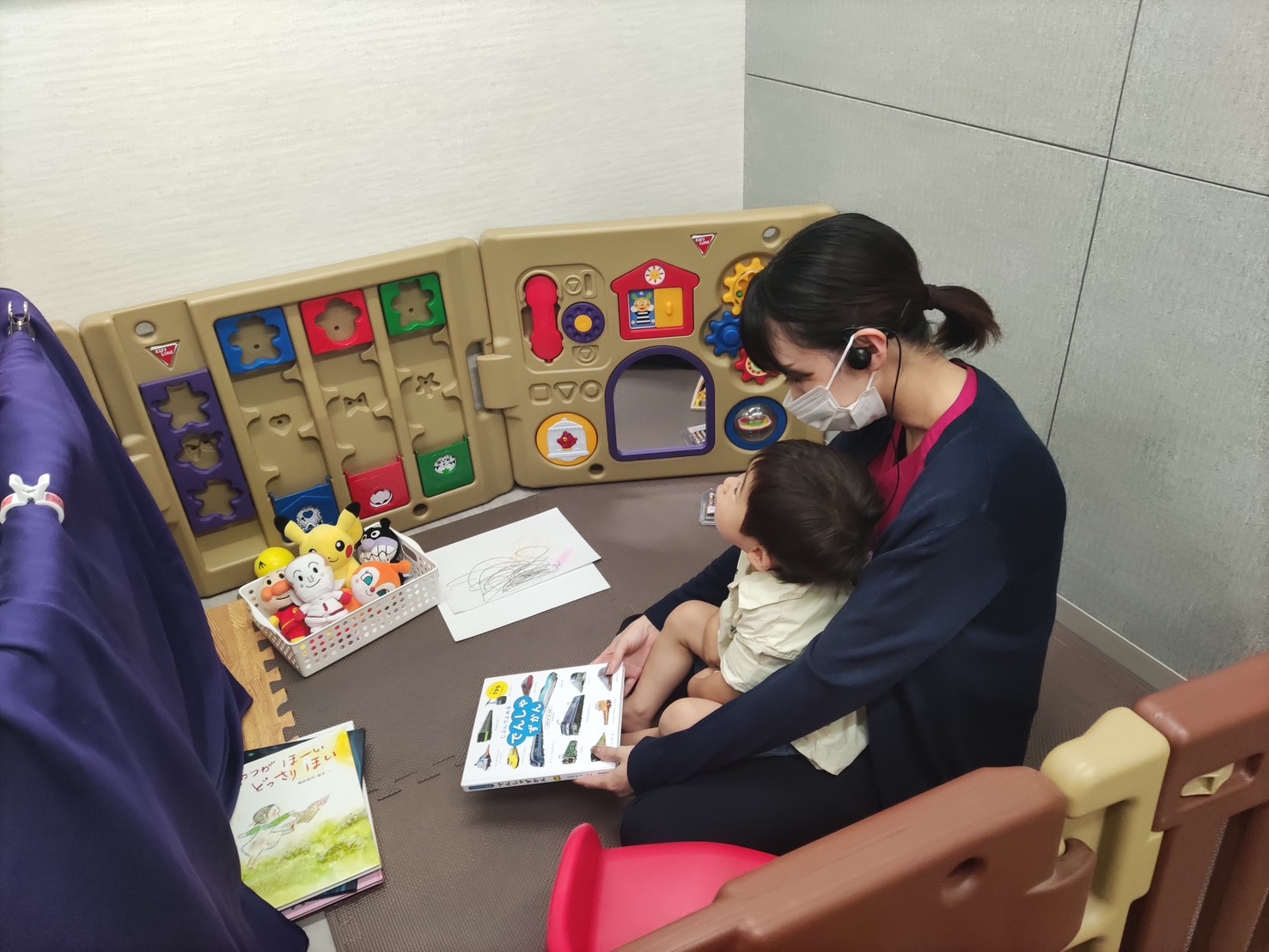 院内の託児スペースで、お子さまと絵本を読むスタッフ